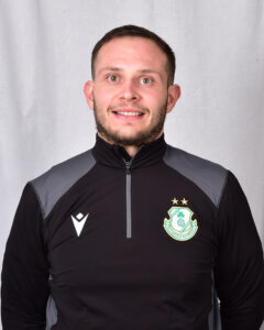 Close-up of a Shamrock Rovers football player in team kit, smiling at camera.