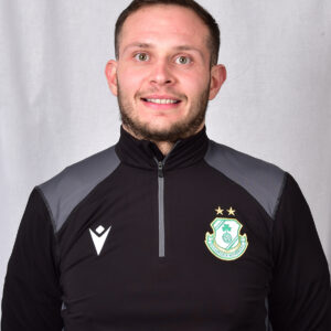 Close-up of a Shamrock Rovers football player in team kit, smiling at camera.