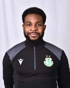 Shamrock Rovers player in team kit, smiling, standing against a plain background.
