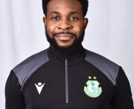 Shamrock Rovers player in team kit, smiling, standing against a plain background.