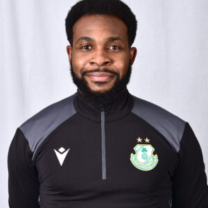 Shamrock Rovers player in team kit, smiling, standing against a plain background.