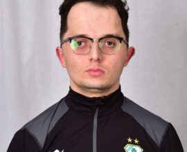 Shamrock Rovers player in team kit with club crest, facing forward.