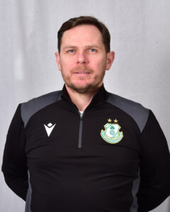 Portrait of Shamrock Rovers coach in team gear, facing camera.