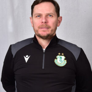 Portrait of Shamrock Rovers coach in team gear, facing camera.