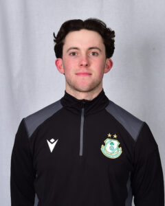 Young Shamrock Rovers football player in team kit, facing camera.