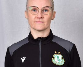 Female Shamrock Rovers player in team jacket with club crest.