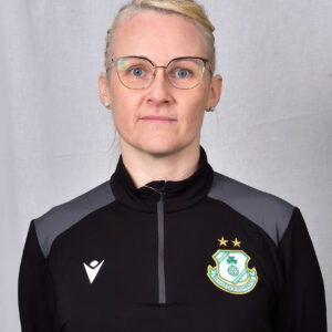 Female Shamrock Rovers player in team jacket with club crest.