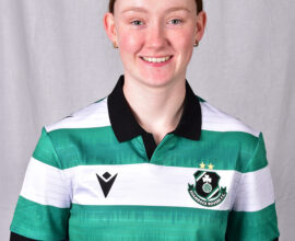 Female football player in Shamrock Rovers kit smiling.
