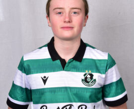 Female Shamrock Rovers player in green and white jersey, standing confidently.