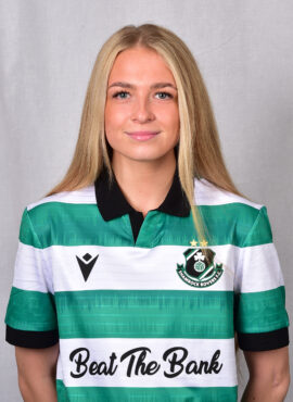 Female footballer in Shamrock Rovers jersey smiling at camera.