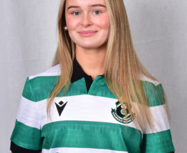 Female football player in Shamrock Rovers jersey smiling.