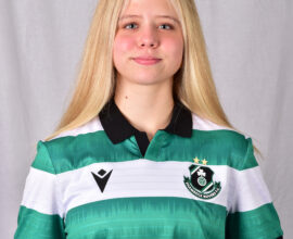 Young female Shamrock Rovers player in team jersey, smiling confidently.