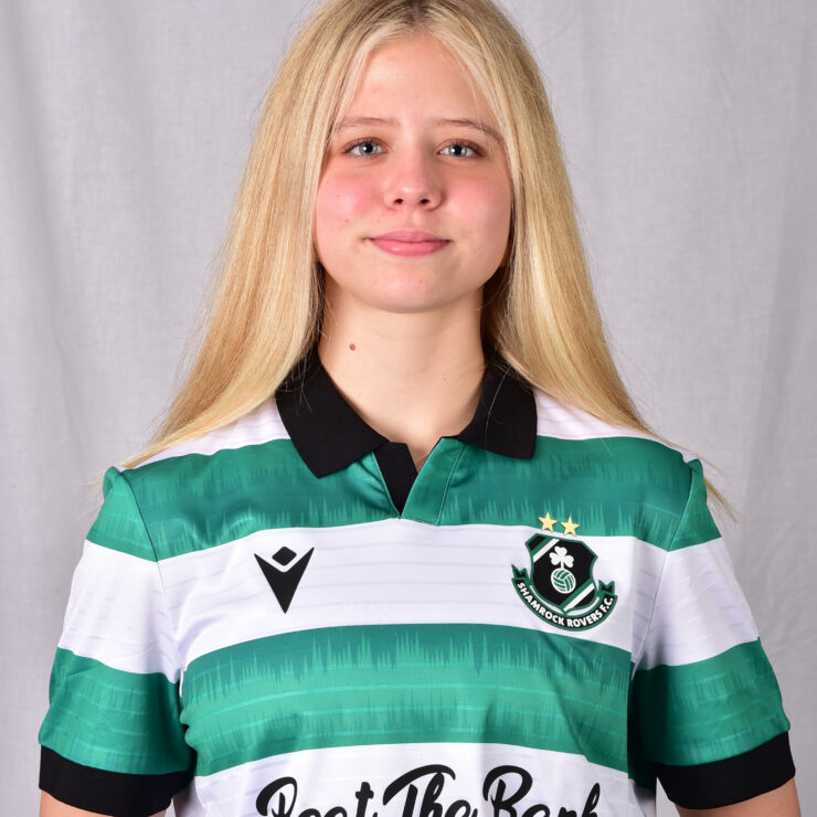 Young female Shamrock Rovers player in team jersey, smiling confidently.