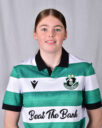 Female Shamrock Rovers player in team jersey smiling at camera.