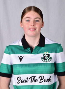 Female Shamrock Rovers player in team jersey smiling at camera.