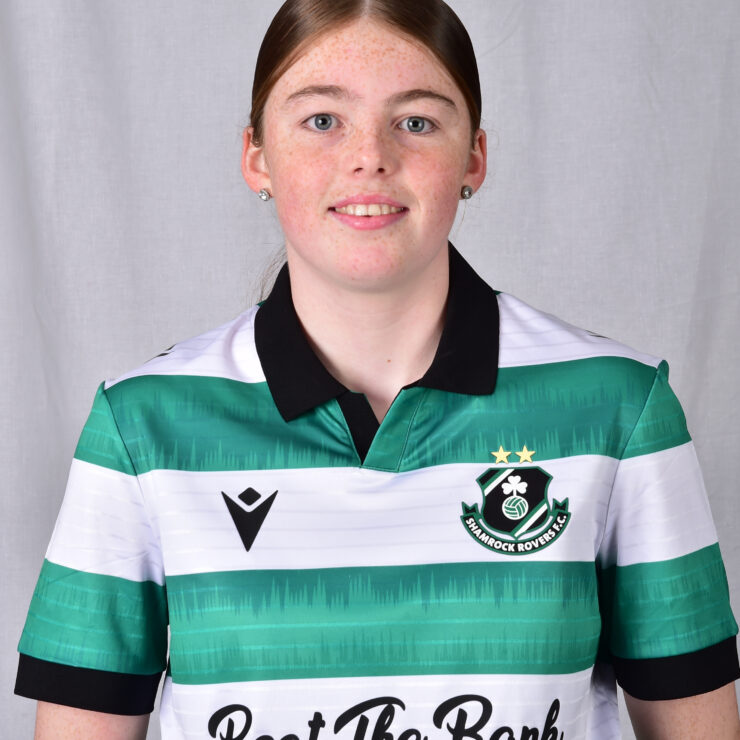 Female Shamrock Rovers player in team jersey smiling at camera.