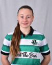 Shamrock Rovers female football player in team jersey, smiling confidently.