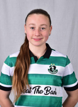 Shamrock Rovers female football player in team jersey, smiling confidently.