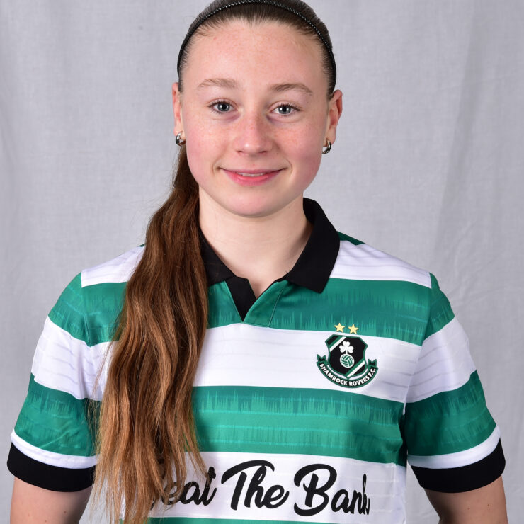 Shamrock Rovers female football player in team jersey, smiling confidently.