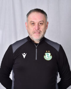 Portrait of Shamrock Rovers coach in team gear, facing camera.