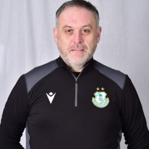 Portrait of Shamrock Rovers coach in team gear, facing camera.
