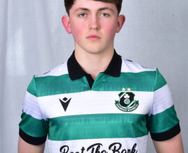 Young Shamrock Rovers player in team jersey, standing confidently.