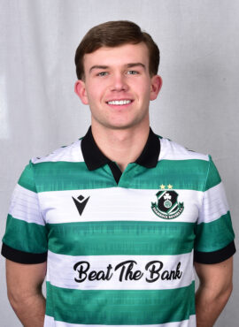 Young Shamrock Rovers footballer in green and white kit smiling at camera.