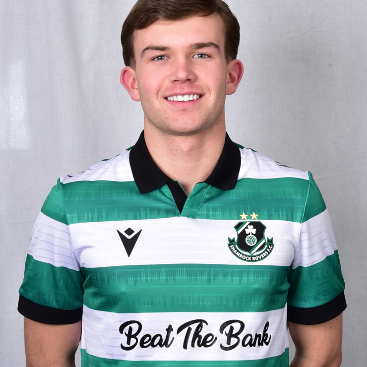 Young Shamrock Rovers footballer in green and white kit smiling at camera.