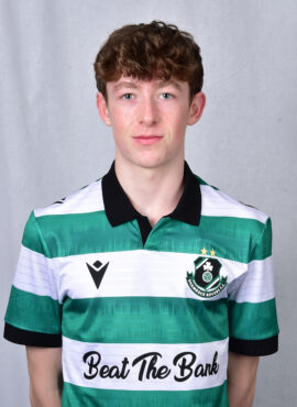 Young Shamrock Rovers player in team jersey, standing against grey background.