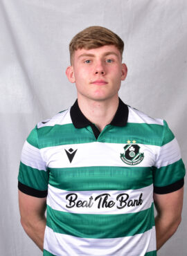 Young Shamrock Rovers footballer in green and white kit, standing confidently.