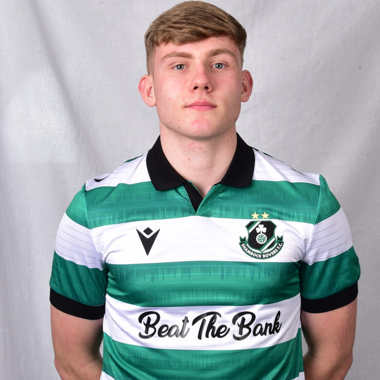 Young Shamrock Rovers footballer in green and white kit, standing confidently.