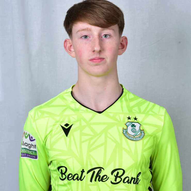 Young Shamrock Rovers goalkeeper in bright green kit with club crest.