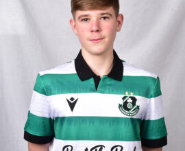 Young football player in Shamrock Rovers kit with green and white stripes.