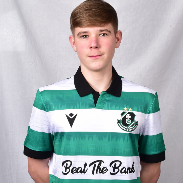 Young football player in Shamrock Rovers kit with green and white stripes.