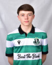 Young Shamrock Rovers player in team jersey, standing against a grey background.