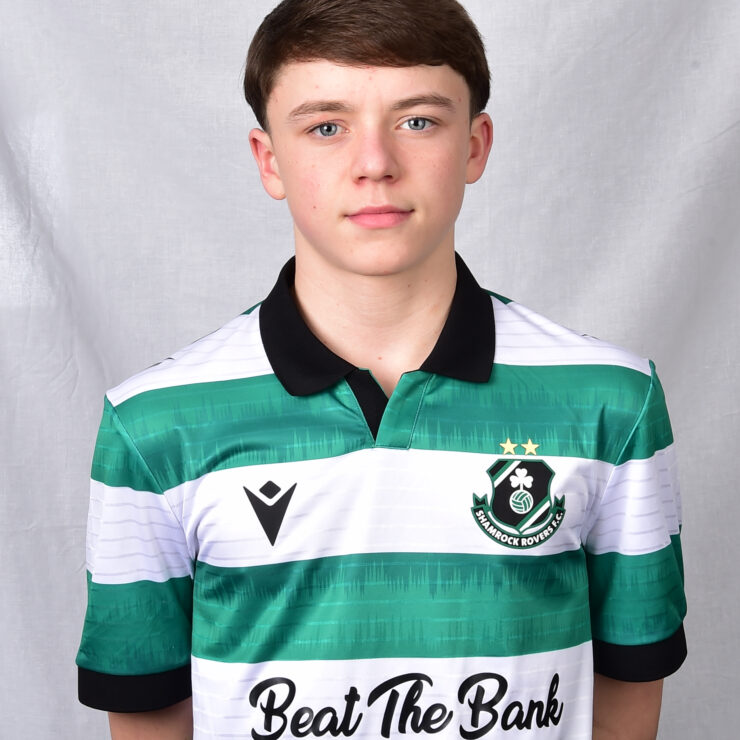 Young Shamrock Rovers player in team jersey, standing against a grey background.