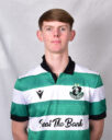 Young Shamrock Rovers player in team jersey, standing against grey background.