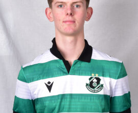 Young Shamrock Rovers player in team jersey, standing against grey background.