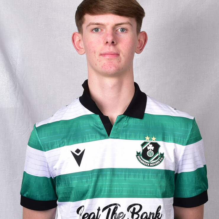 Young Shamrock Rovers player in team jersey, standing against grey background.