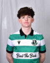 Young Shamrock Rovers player in team jersey, standing against a grey background.