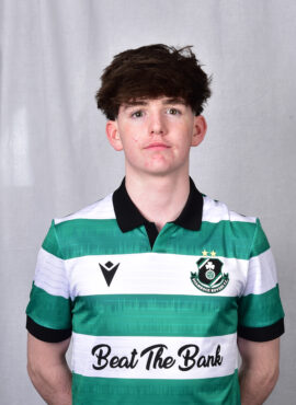 Young Shamrock Rovers player in team jersey, standing against a grey background.