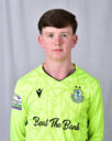 Young Shamrock Rovers player in bright green kit, standing against a grey background.