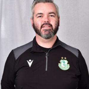 Close-up of Shamrock Rovers player in team kit, smiling.