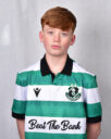 Young Shamrock Rovers player in green and white jersey, standing against a grey background.