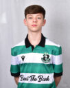 Young Shamrock Rovers player in team jersey, standing against grey background.