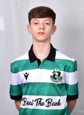 Young Shamrock Rovers player in team jersey, standing against grey background.
