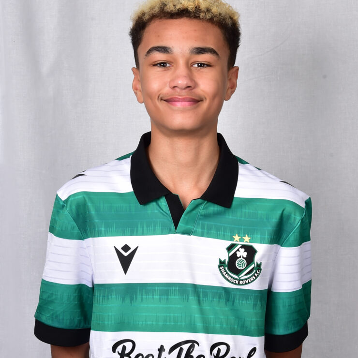 Young Shamrock Rovers player in green and white jersey smiling.