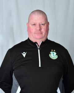 Portrait of Shamrock Rovers coach in team gear, facing camera.