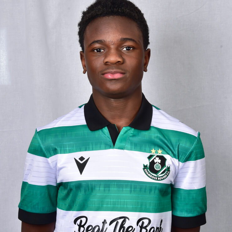 Young Shamrock Rovers player in green and white kit, standing confidently.
