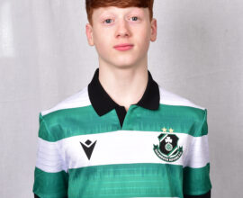 Young Shamrock Rovers player in green and white jersey, standing confidently.